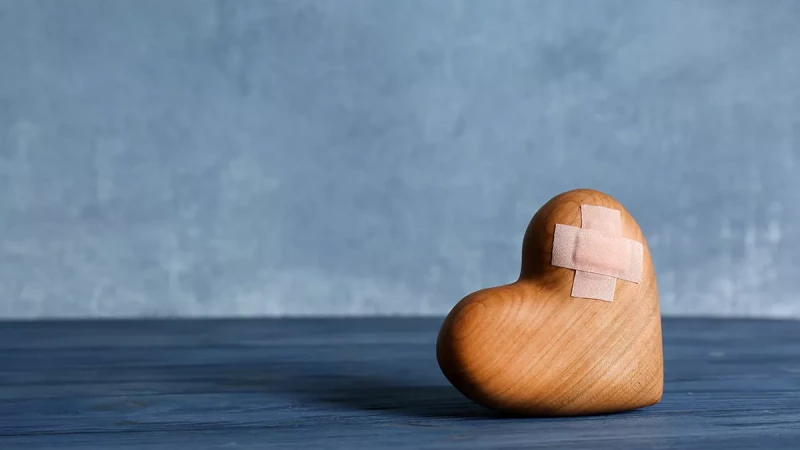 wooden heart with a bandage over it