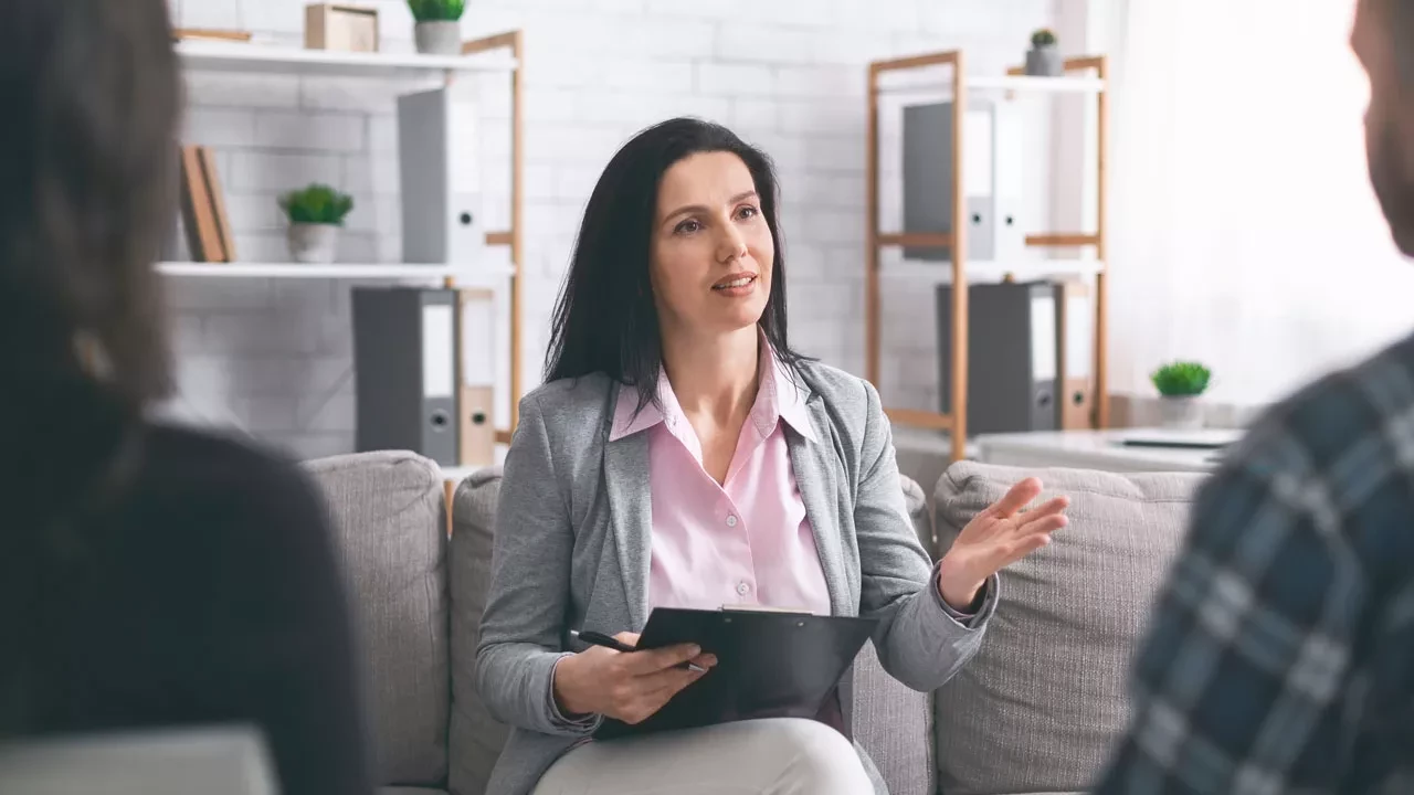 Female therapist talking with a clipboard in her hand