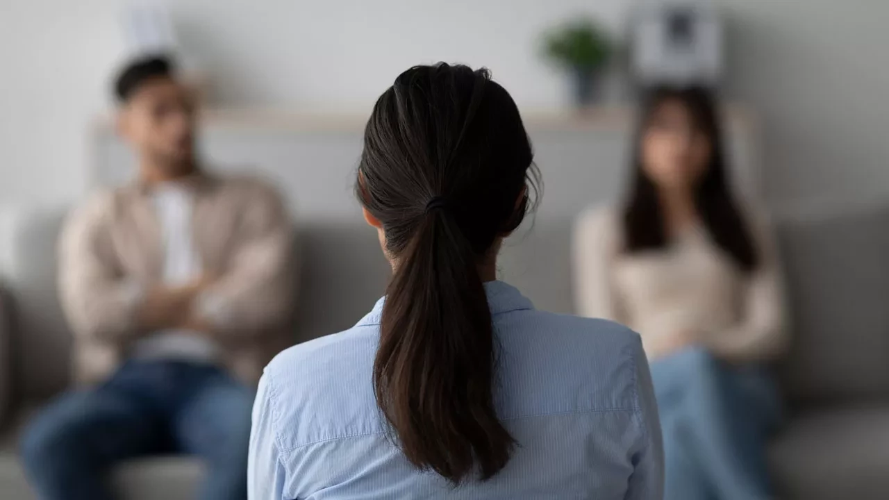 Therapist with her back turned talking to a couple