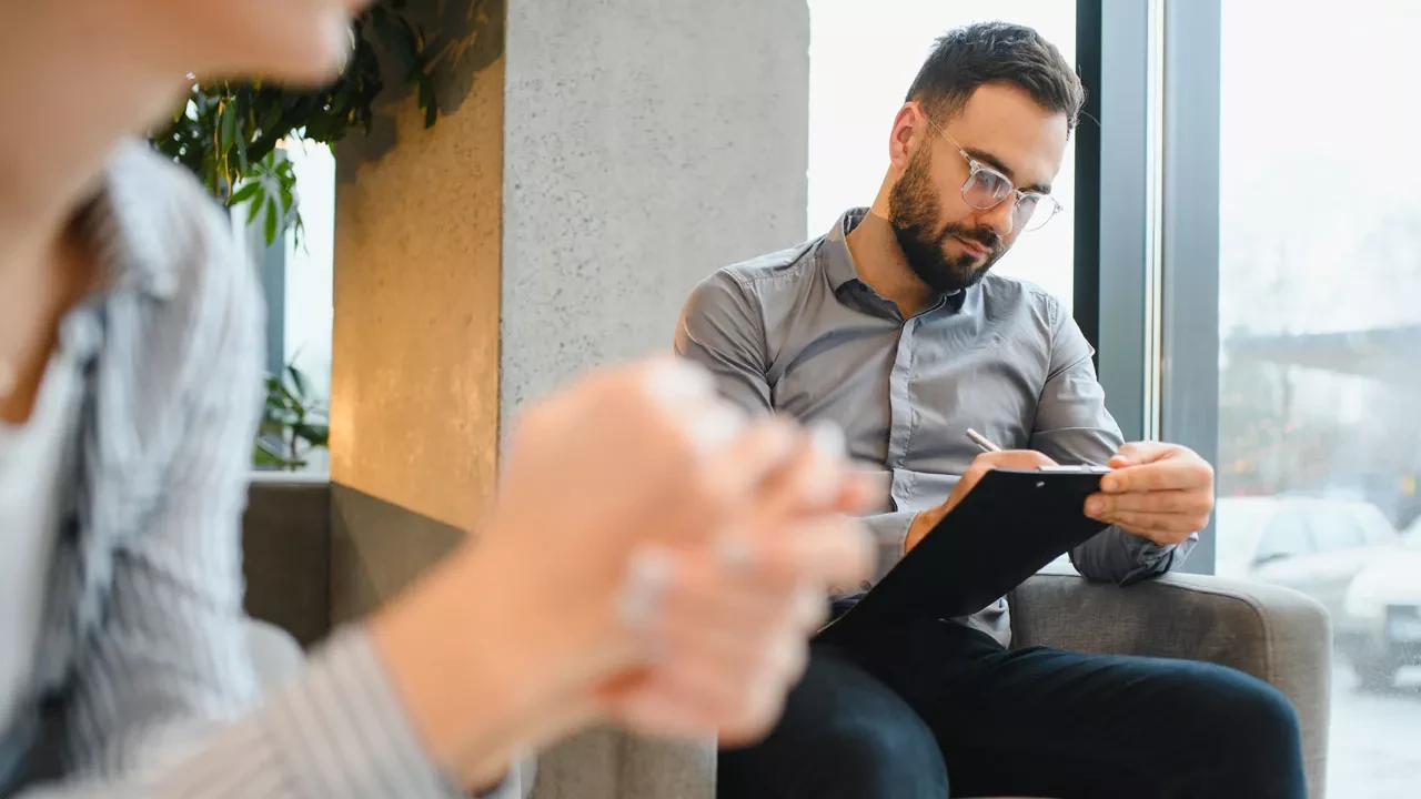 Therapist writing on a clipboard