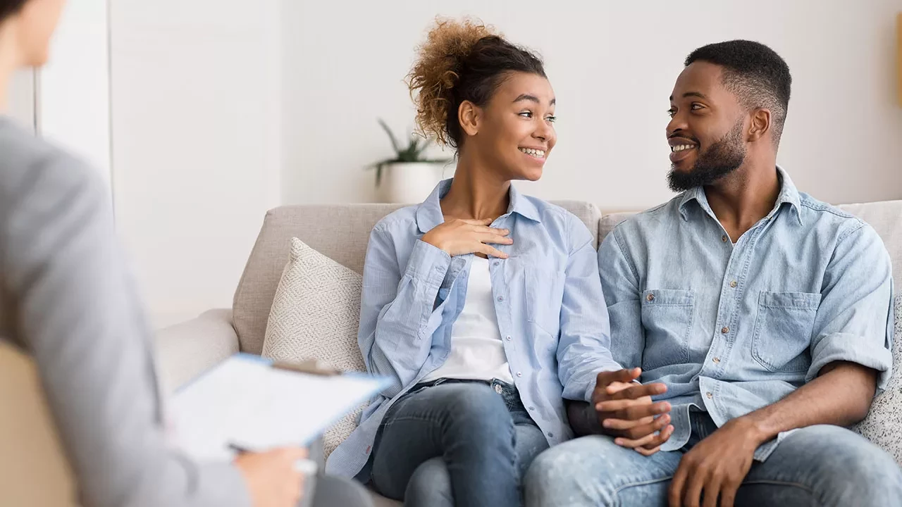Couple holding hands on a couch