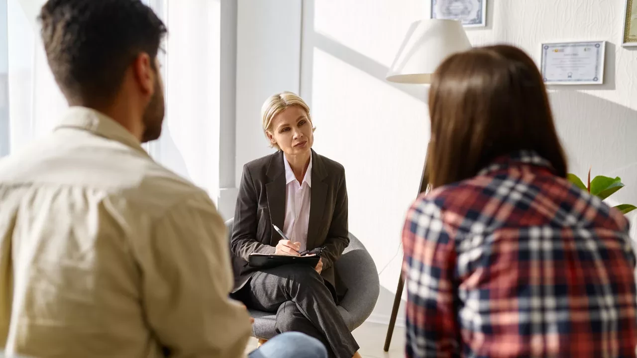 Female therapist sitting with a couple during a session