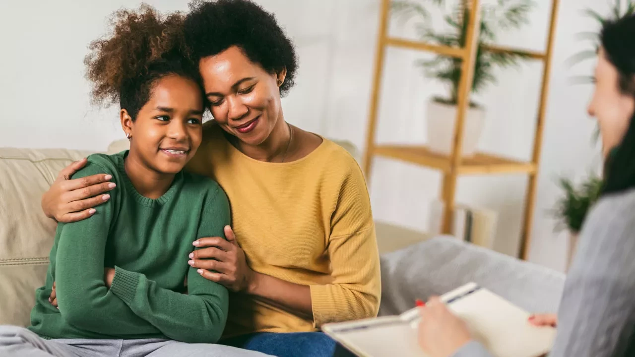 Mother and her teenager daughter talking with therapist