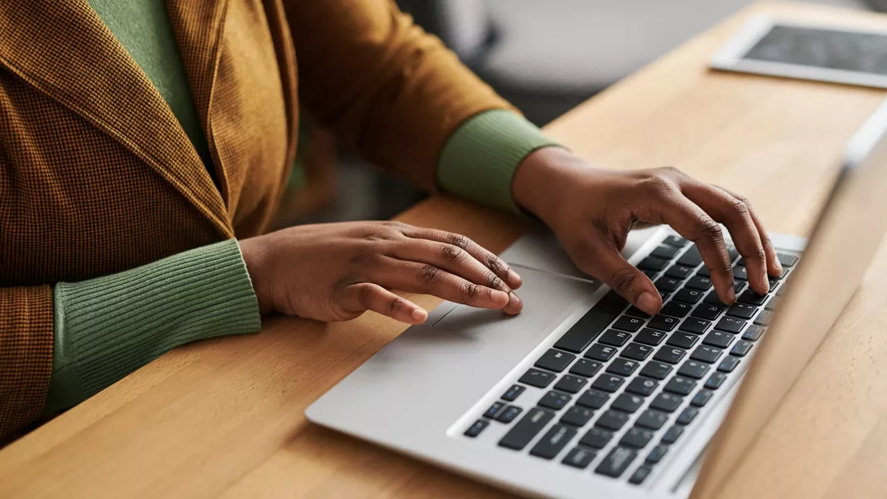 Person typing on a silver laptop