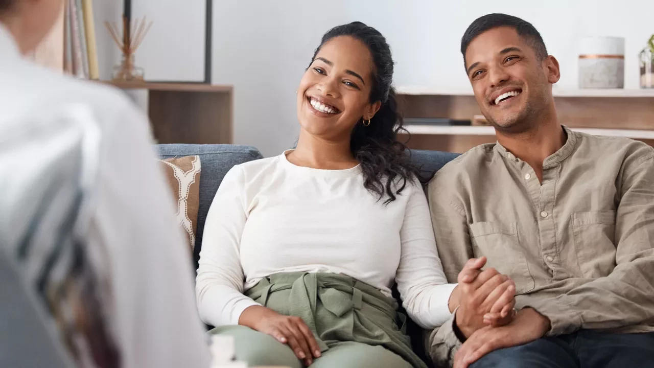 a couple smiling on a couch together