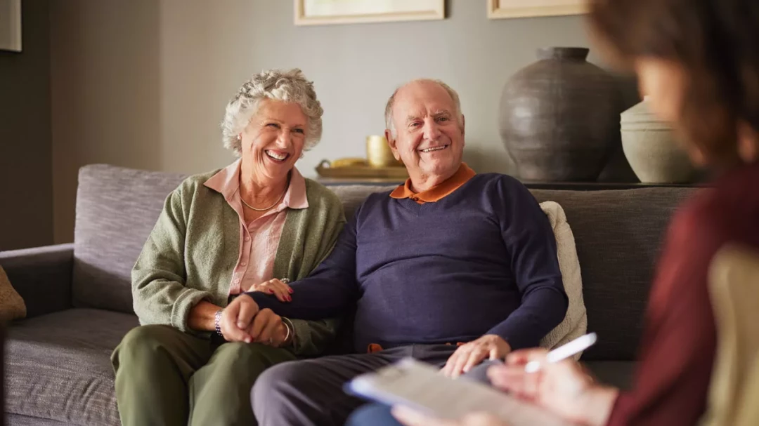 Older couple holding hands talking to a therapist