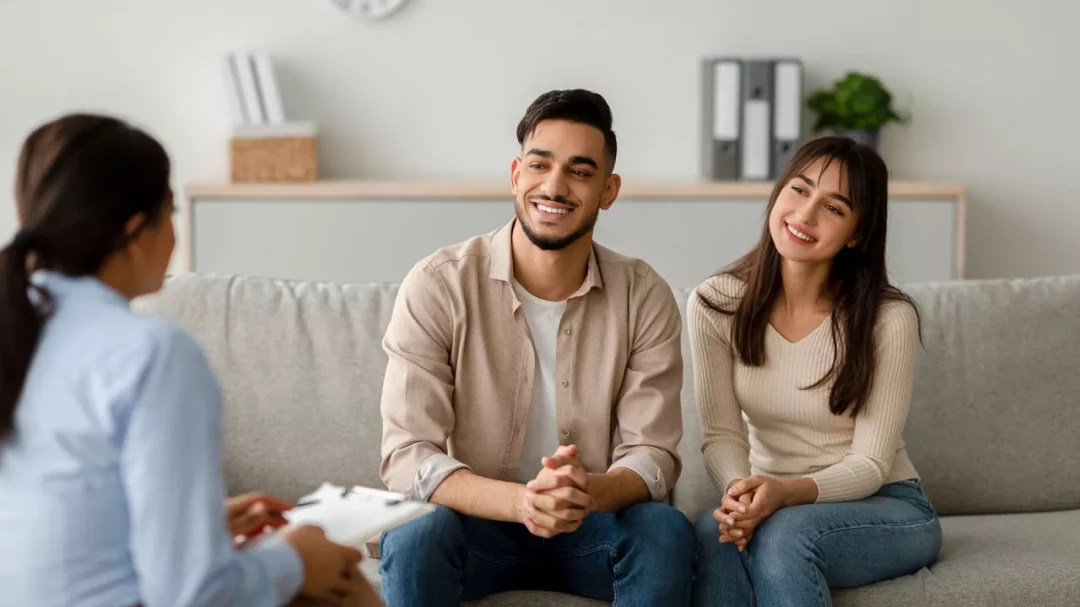 Happy couple sitting with a therapist