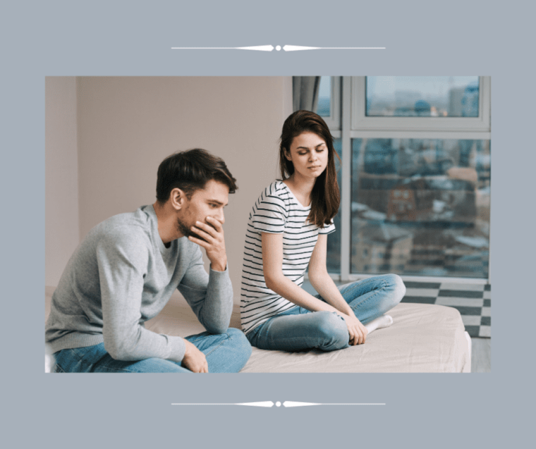 Couple sitting on bed figuring out issues