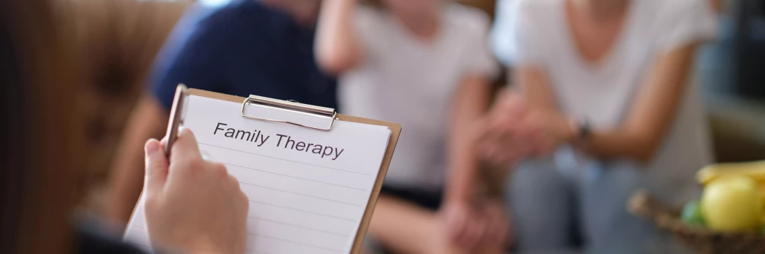 Therapist writing down notes on family