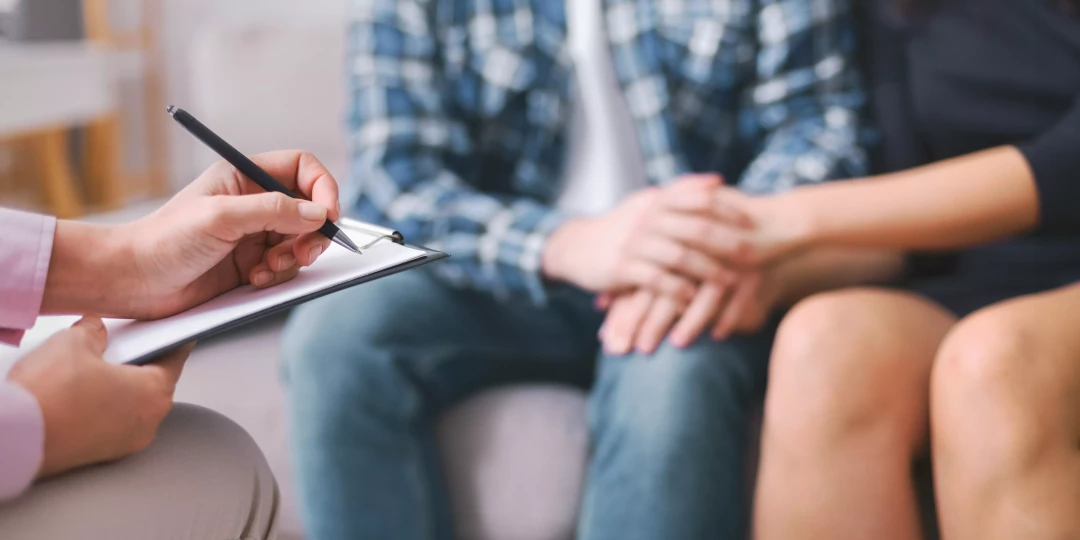 Therapist taking notes on couple