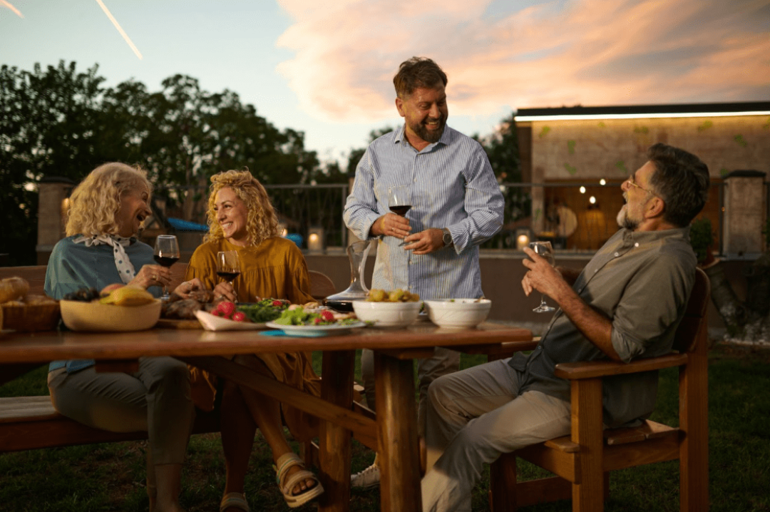 2 adult couples having dinner on the patio