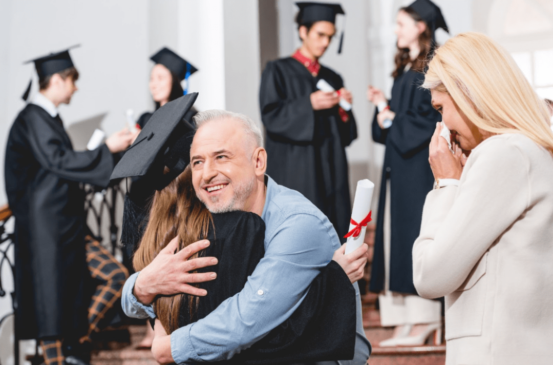 dad hugging child in graduation ceremony