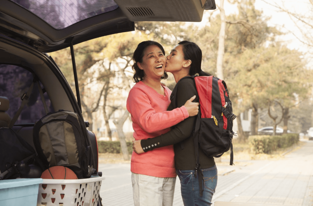 college student kissing mom goodbye